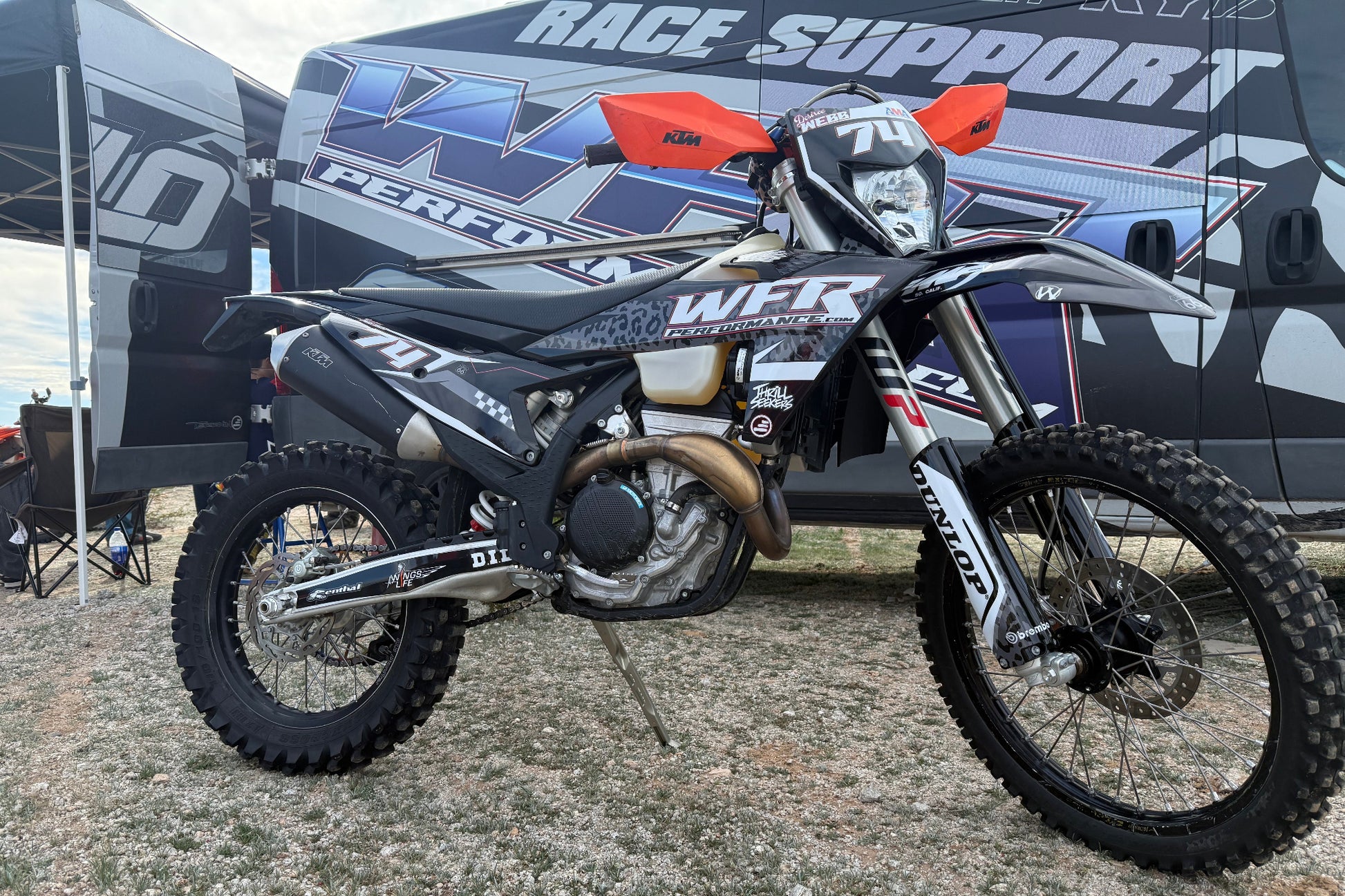 Motocross bike with WFX branding in front of a van labeled 'Race Support'.